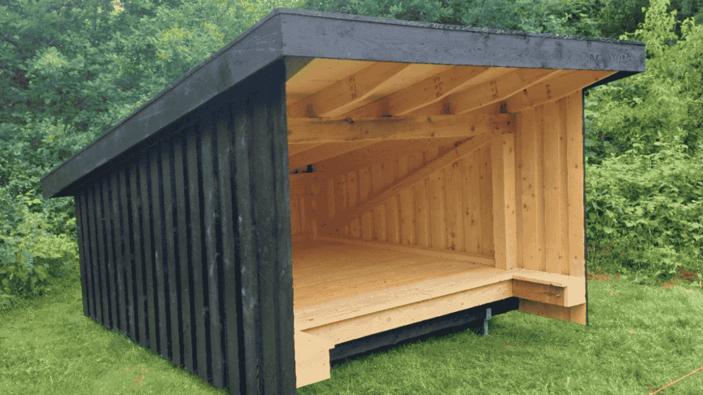 Schwarz gestrichener Shelter auf grüner Wiese